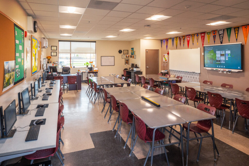 Interior view of a modern computer lab at Greenfield High School, featuring workstations and a collaborative seating arrangement for students.