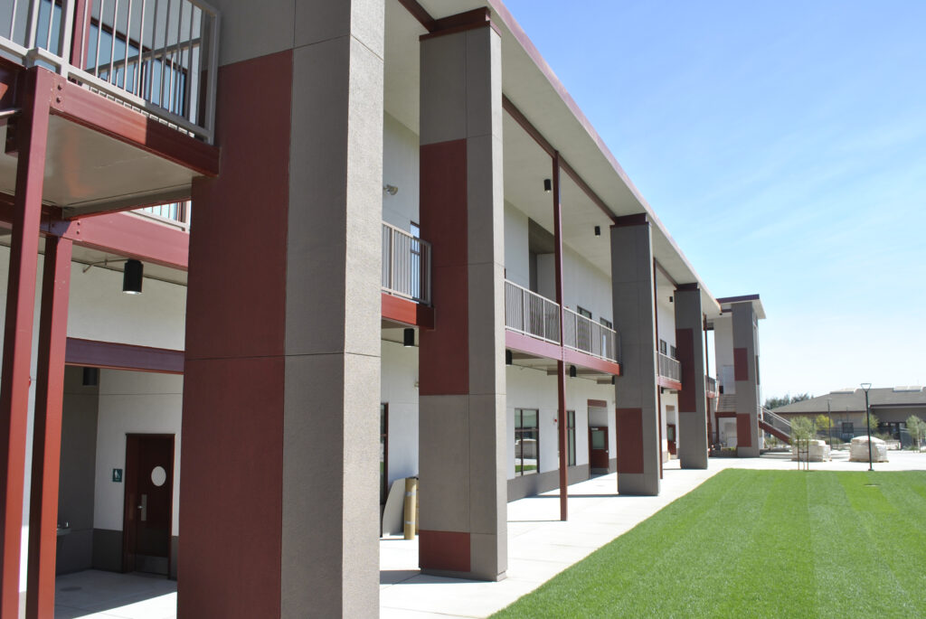 A side view of the Greenfield High School modular building, showcasing the two-story structure and exterior walkways.