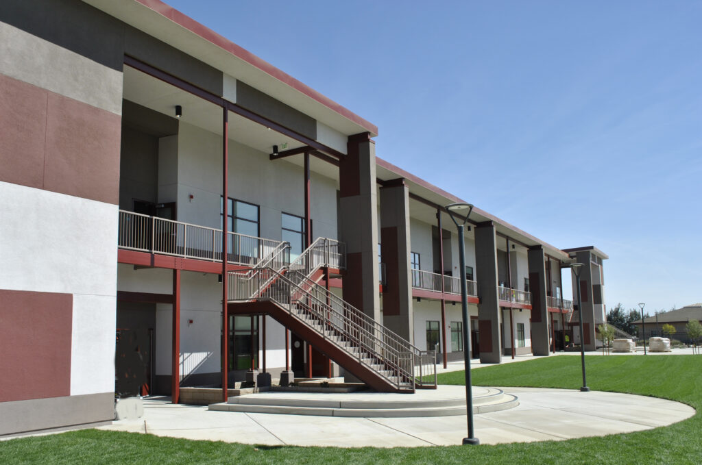 Front view of the Greenfield High School two-story modular classroom building with outdoor stairs and balconies for classroom access.