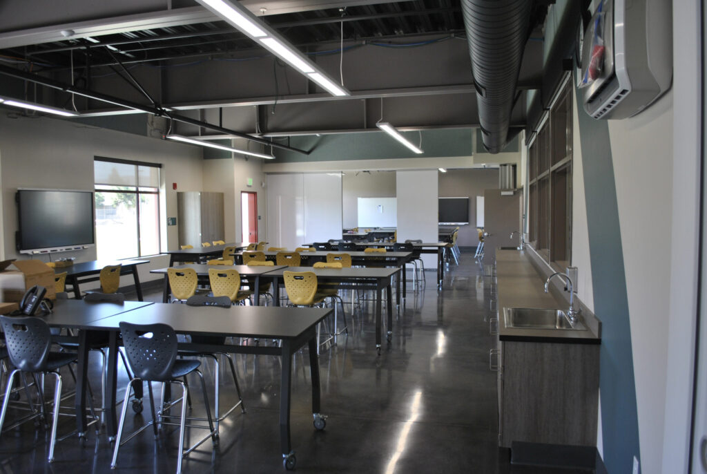 Interior view of a general classroom at Greenfield High School with large windows, modern desks, and lighting.