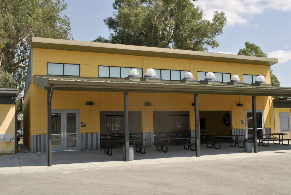 Exterior of the ACE Empower Academy multipurpose building, featuring a modern design with roll-up doors.