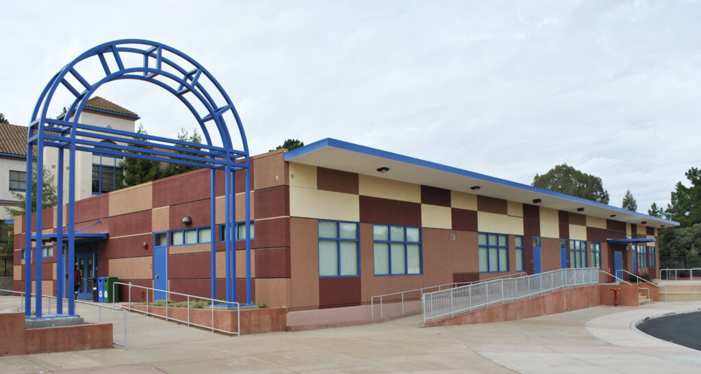 This image showcases the exterior of Alhambra High School's new modular school building, highlighting the architectural design and the archway that welcomes students and staff.