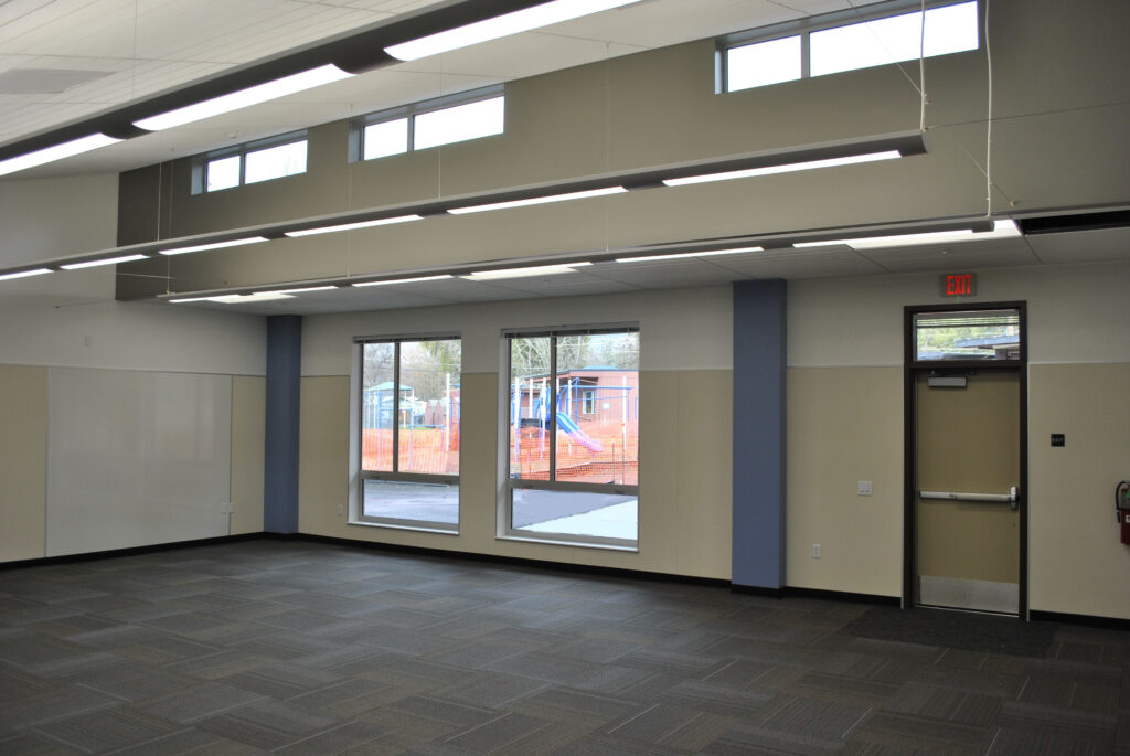 Interior view of a spacious kindergarten classroom at Lucerne Elementary School, featuring large windows and clerestory lighting.