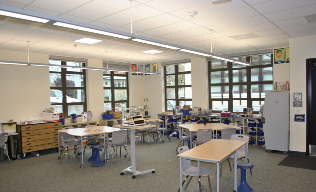 Interior view of modular classroom at Roosevelt Elementary School, showcasing modern desks and large windows providing ample natural light.