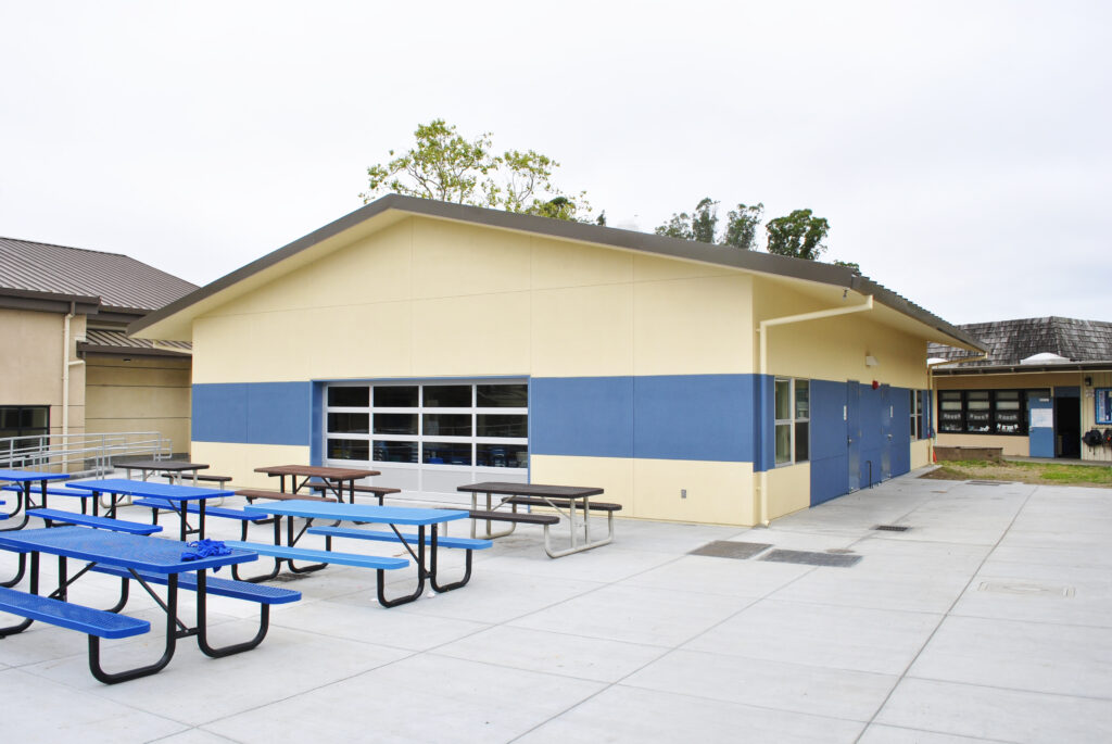 View of the outdoor seating area and modular classroom building at Santa Cruz Gardens Elementary, designed for special education and art classes.