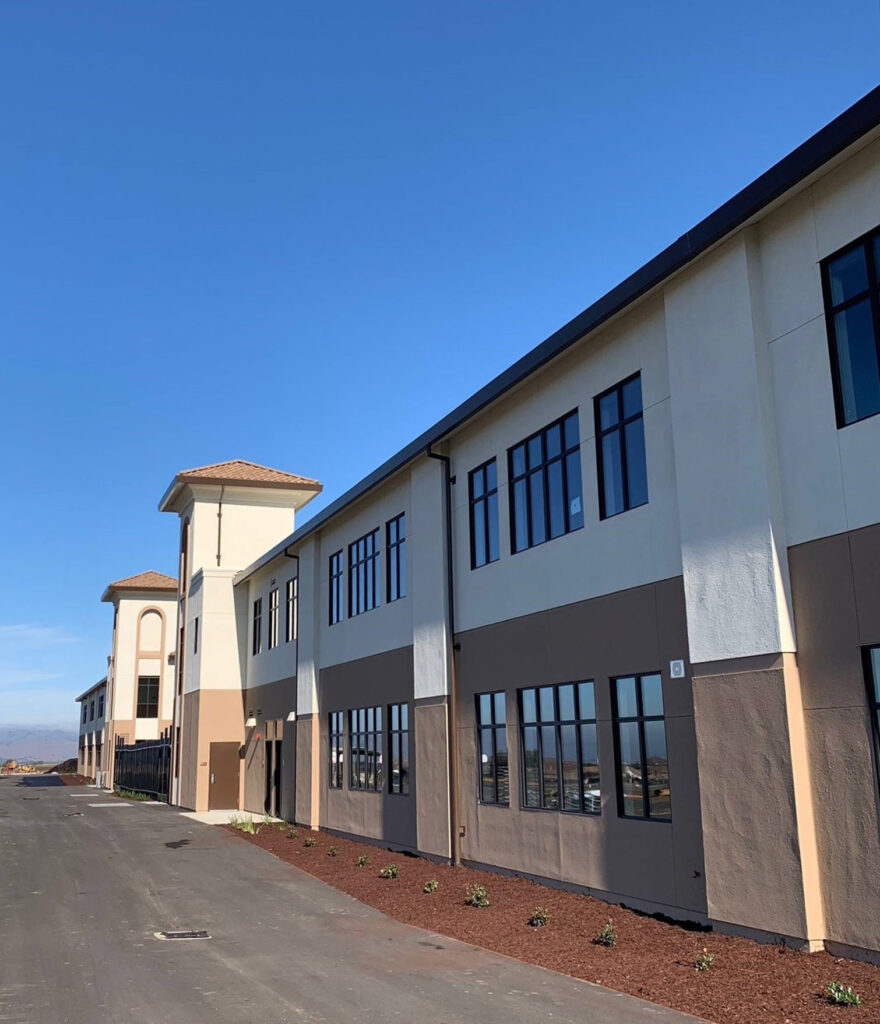 Daytime view of the Rancho Santana School modular buildings with a two-story layout and large windows.