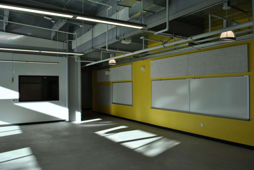 Interior classroom at Rocketship Senter Road Campus with skylights and yellow walls.