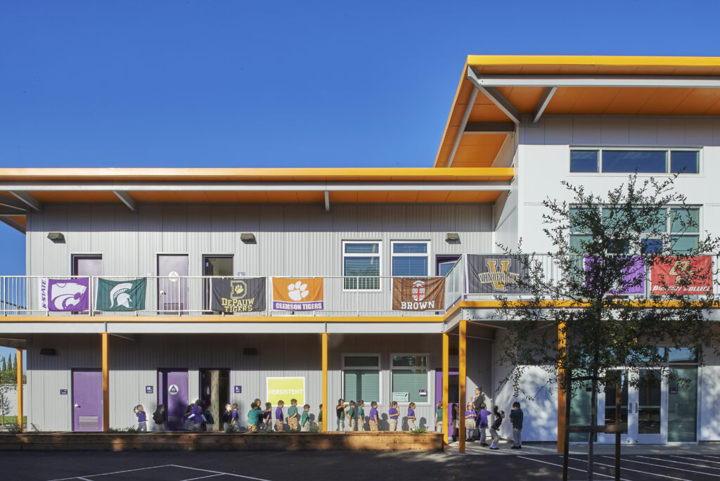 Front view of Rocketship Senter Road Campus with a two-story building and trees lining the student courtyard.