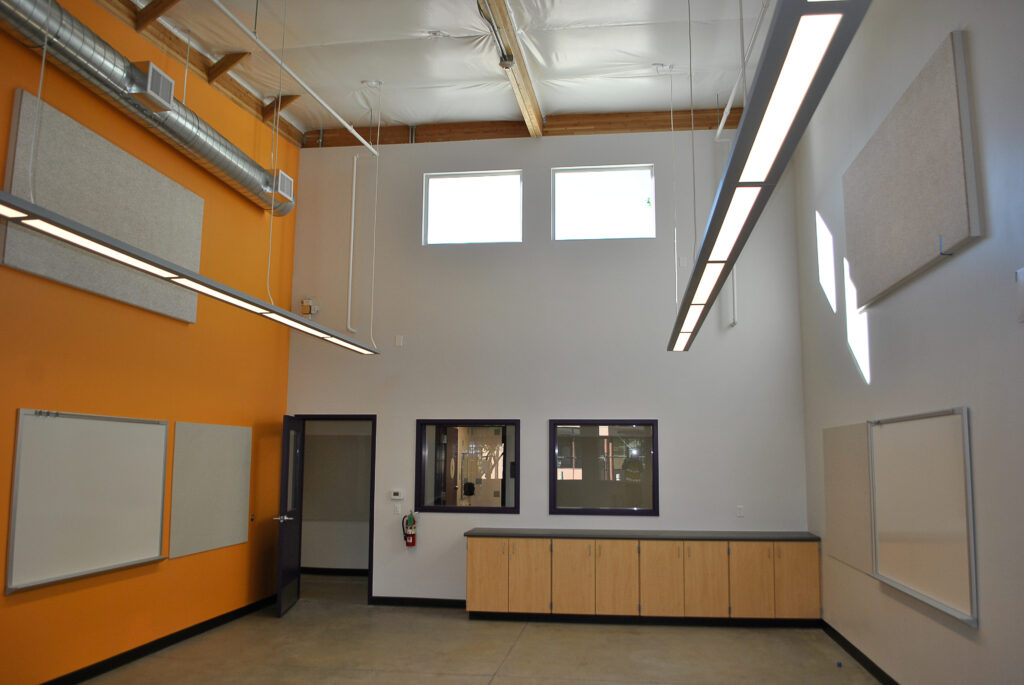 Interior of a Rocketship classroom featuring high ceilings, bright lighting, and a colorful wall with HVAC systems visible.