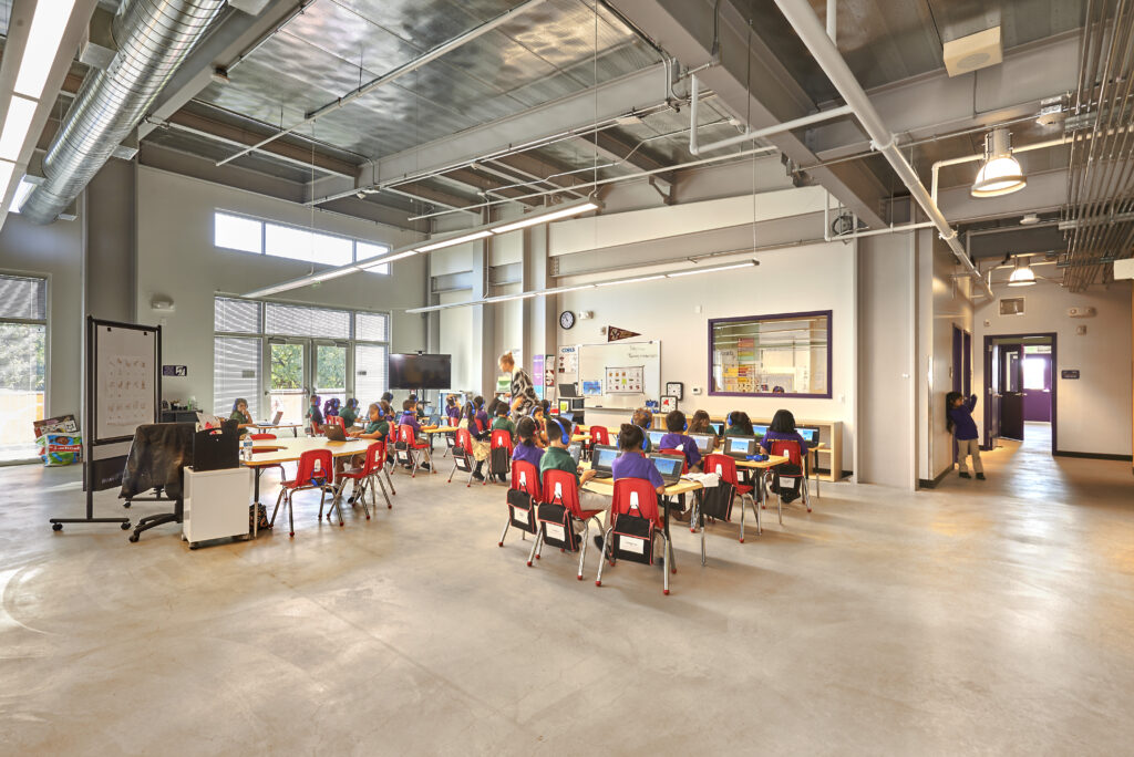 A Rocketship classroom filled with students working on laptops, featuring modern lighting and spacious design.