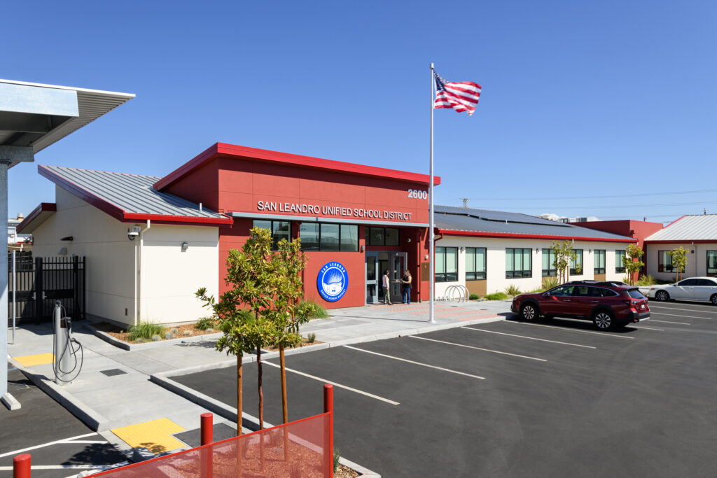 A wide-angle view of the SLUSD district office showcasing the modern entrance, integrated solar-ready roofing, and EV-ready parking facilities.