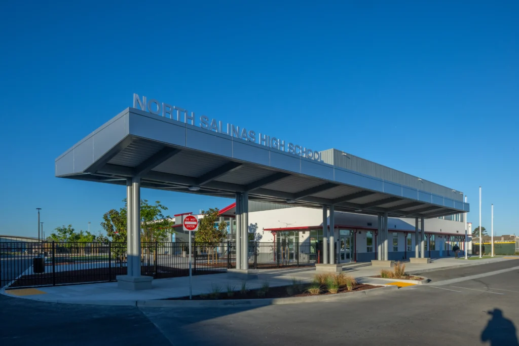 Exterior view of the North Salinas High School entrance featuring a large metal canopy with silver signage.